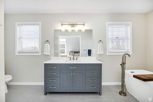 385 N 300 E, Providence, UT 84332 - bathroom featuring a freestanding bath, vanity, toilet, and baseboards