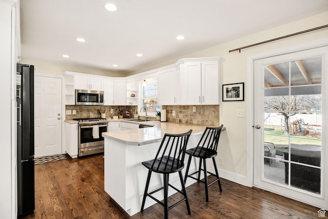 385 N 300 E, Providence, UT 84332 - kitchen with a peninsula, appliances with stainless steel finishes, a sink, open shelves, and dark wood-style floors