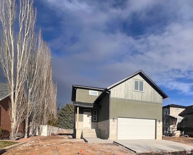 view of front of property with driveway, stucco siding, a garage, and brick siding