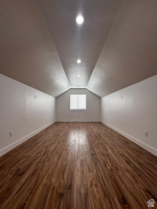 bonus room with a textured ceiling and baseboards
