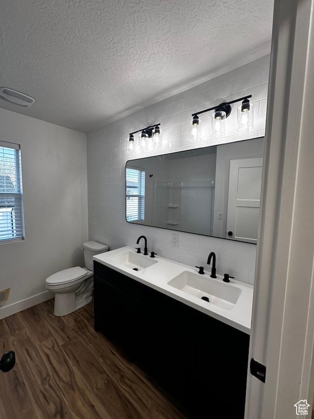 bathroom with a textured ceiling, visible vents, and a sink