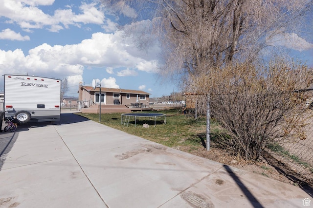 view of front of house with a trampoline and a front yard