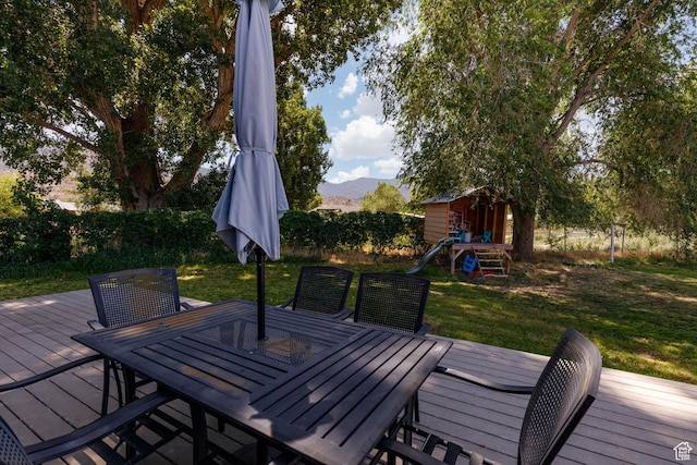 170 E 400 N, Monroe, UT 84754 - deck featuring outdoor dining area, a lawn, a playground, a shed, and a mountain view