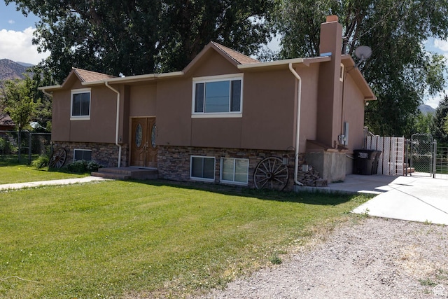 170 E 400 N, Monroe, UT 84754 - split foyer home featuring a chimney, concrete driveway, stucco siding, and stone siding