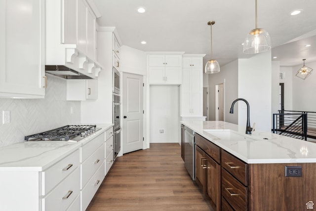 kitchen with white cabinetry, a sink, dark wood-style floors, a kitchen island with sink, and appliances with stainless steel finishes