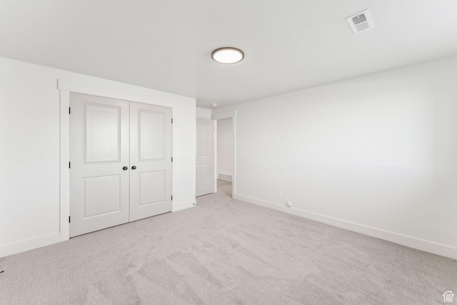 unfurnished bedroom with baseboards, visible vents, a closet, and carpet floors