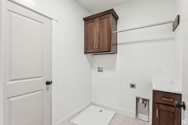 washroom with hookup for an electric dryer, light tile patterned floors, baseboards, cabinet space, and washer hookup