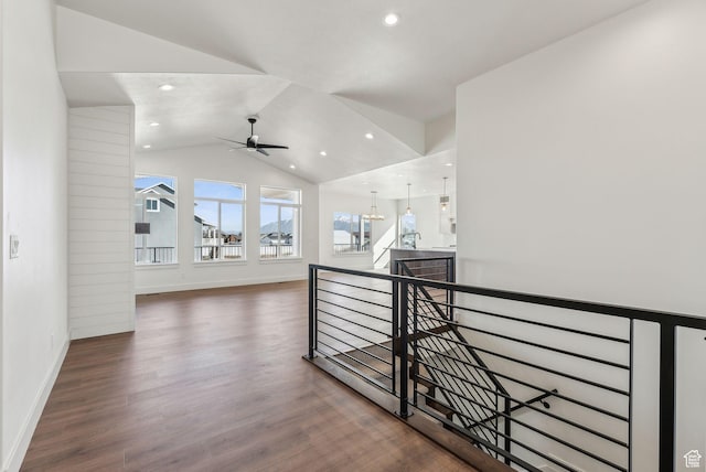 hall featuring vaulted ceiling, an upstairs landing, wood finished floors, baseboards, and recessed lighting