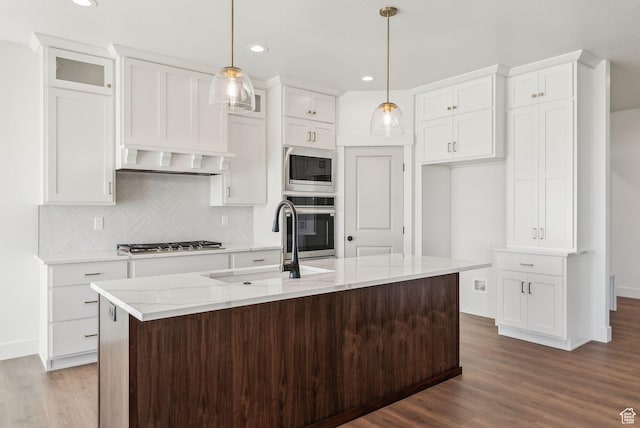 kitchen with dark wood-style flooring, backsplash, white cabinetry, and stainless steel appliances