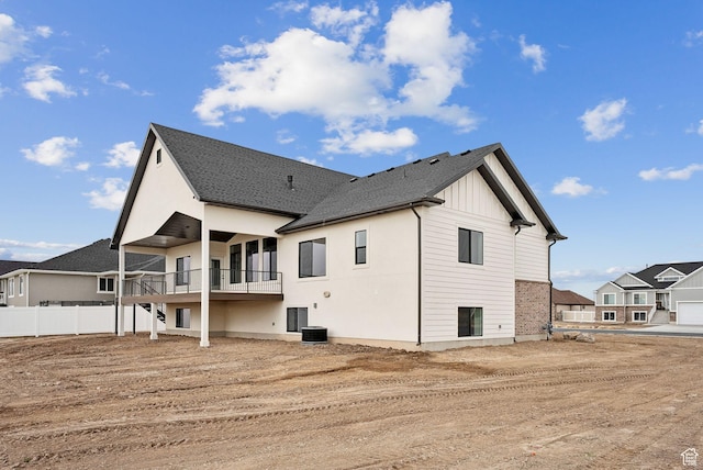 rear view of property with board and batten siding and a balcony