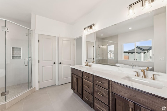 bathroom featuring a stall shower, tile patterned floors, double vanity, and a sink