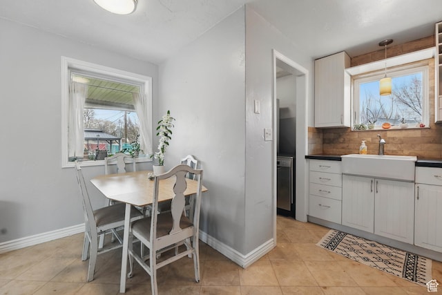 2645 S Masonic Cir E, South Salt Lake, UT 84115 - kitchen featuring a sink, tasteful backsplash, light tile patterned floors, baseboards, and dark countertops