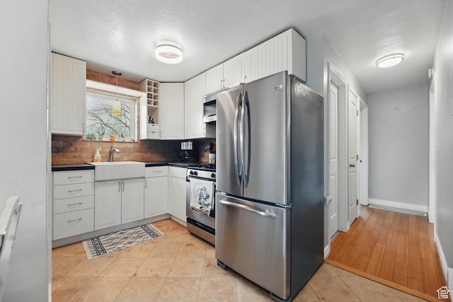 2645 S Masonic Cir E, South Salt Lake, UT 84115 - kitchen featuring white cabinets, a sink, dark countertops, and appliances with stainless steel finishes