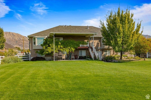 3011 N 1000 W, Pleasant View, UT 84414 - back of property featuring stairway, fence, a mountain view, brick siding, and a yard