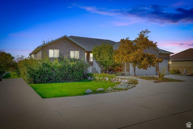3011 N 1000 W, Pleasant View, UT 84414 - view of front of home featuring a lawn, an attached garage, brick siding, and concrete driveway
