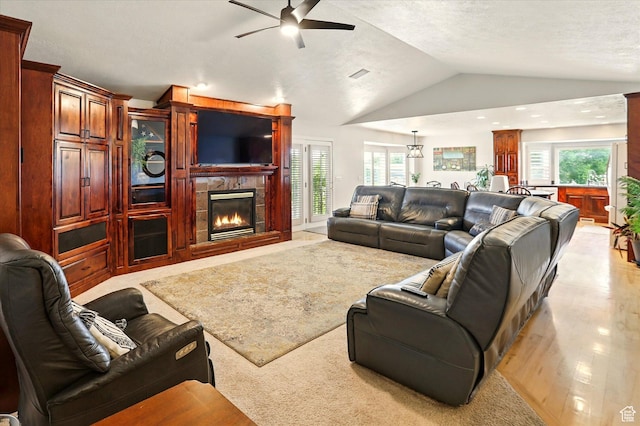 3011 N 1000 W, Pleasant View, UT 84414 - living room featuring a ceiling fan, lofted ceiling, a tile fireplace, plenty of natural light, and light wood-style floors