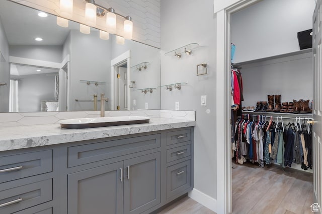 376 W Golden Harvest Rd, Draper, UT 84020 - bathroom featuring vanity, a walk in closet, recessed lighting, baseboards, and wood finished floors