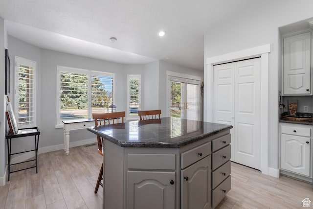 376 W Golden Harvest Rd, Draper, UT 84020 - kitchen with light wood-style flooring, baseboards, dark stone counters, a kitchen island, and gray cabinets