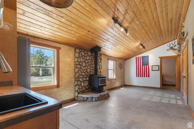 376 W Golden Harvest Rd, Draper, UT 84020 - unfurnished living room featuring rail lighting, vaulted ceiling, a wood stove, concrete floors, and wood ceiling