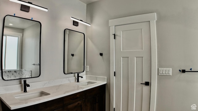 full bathroom with a sink and double vanity
