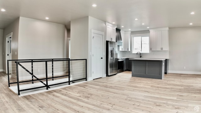 kitchen with light wood-type flooring, a sink, baseboards, and stainless steel refrigerator with ice dispenser