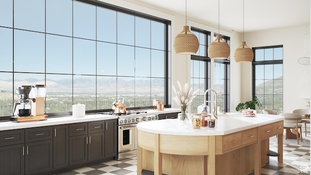 kitchen with light countertops, light floors, decorative light fixtures, range with two ovens, and a mountain view