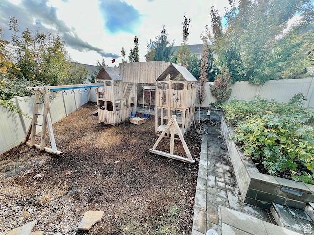 view of play area with a garden and a fenced backyard