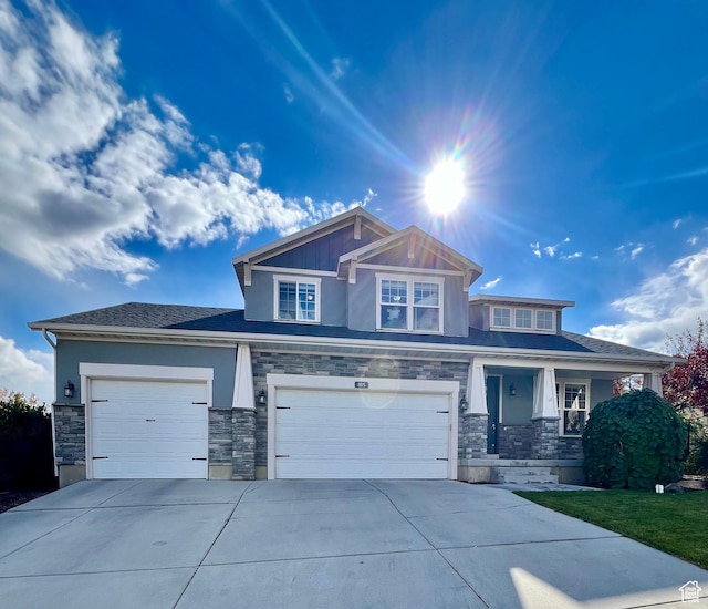 craftsman inspired home with concrete driveway, stucco siding, stone siding, a porch, and a garage