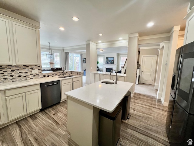 kitchen with backsplash, a sink, a peninsula, stainless steel dishwasher, and smart refrigerator