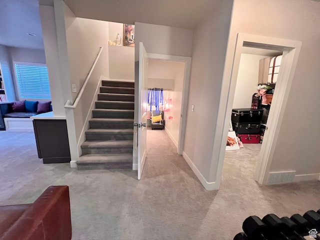 stairway featuring carpet floors, baseboards, and visible vents