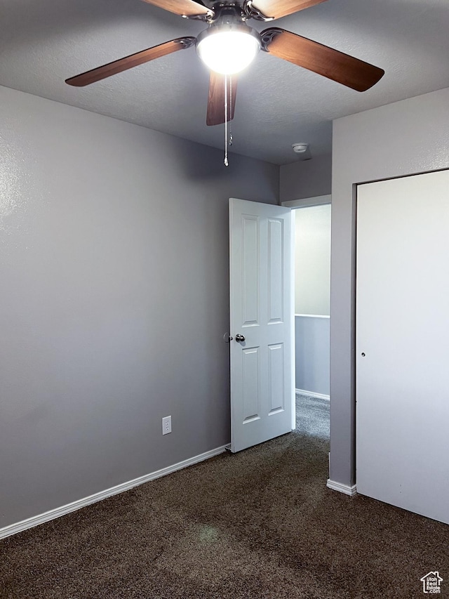 5498 Scarsborough Way, Stansbury Park, UT 84074 - unfurnished bedroom with dark colored carpet, a ceiling fan, a closet, and baseboards