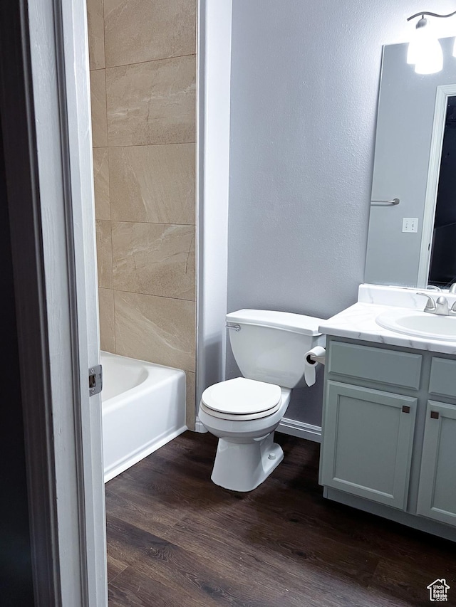 5498 Scarsborough Way, Stansbury Park, UT 84074 - bathroom featuring vanity, toilet, wood finished floors, baseboards, and tub / shower combination