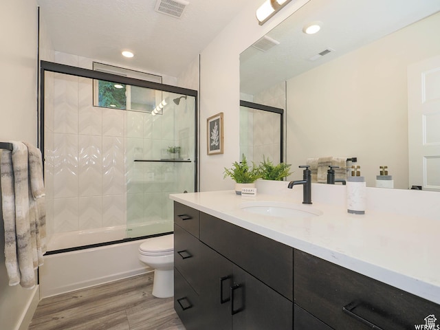 bathroom featuring wood finished floors, vanity, toilet, and visible vents