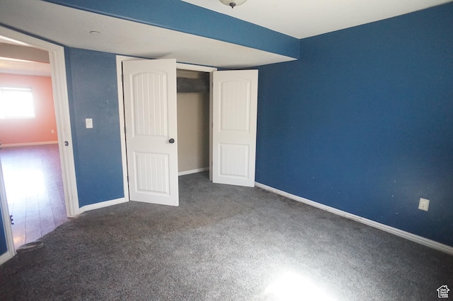 unfurnished bedroom with baseboards, a closet, and carpet