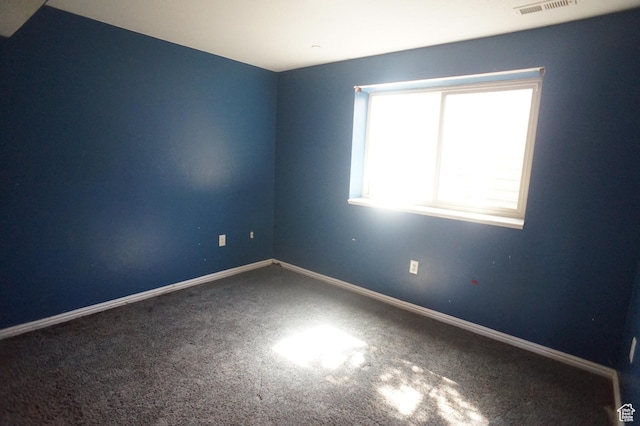 carpeted spare room with baseboards and visible vents