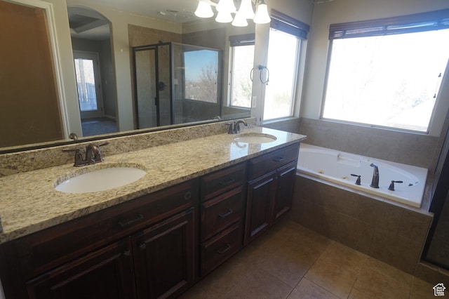 bathroom featuring a healthy amount of sunlight, a sink, and a stall shower