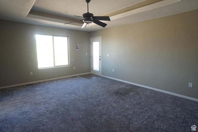 spare room with a tray ceiling, baseboards, ceiling fan, and carpet flooring