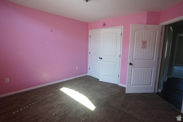 unfurnished bedroom featuring a closet, carpet flooring, and baseboards