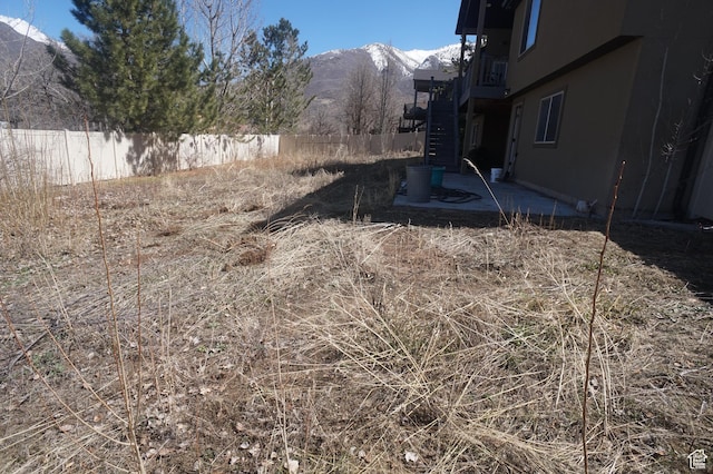 view of yard with stairway, a mountain view, fence, and a patio area