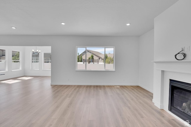 253 E Polaris Dr Unit 105, Saratoga Springs, UT 84045 - unfurnished living room with a fireplace, a chandelier, light wood-style floors, and recessed lighting
