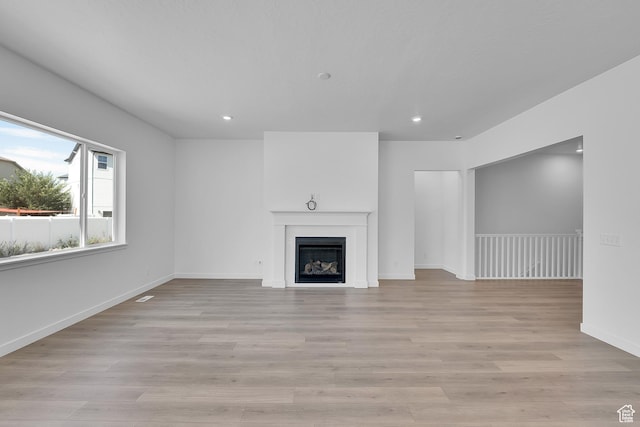 253 E Polaris Dr Unit 105, Saratoga Springs, UT 84045 - unfurnished living room with recessed lighting, light wood-type flooring, and a fireplace