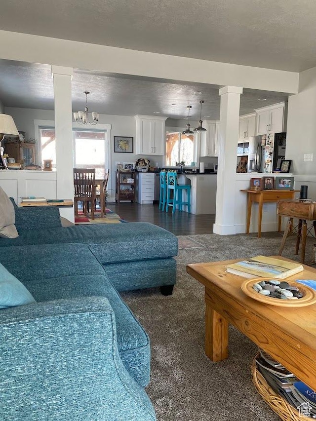 1869 Southpointe Ct, Logan, UT 84341 - living area featuring decorative columns, a chandelier, and a textured ceiling