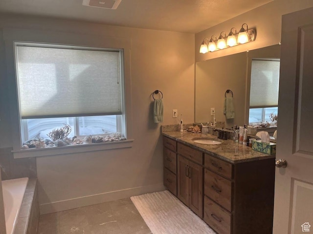 1869 Southpointe Ct, Logan, UT 84341 - bathroom featuring baseboards, a relaxing tiled tub, and vanity
