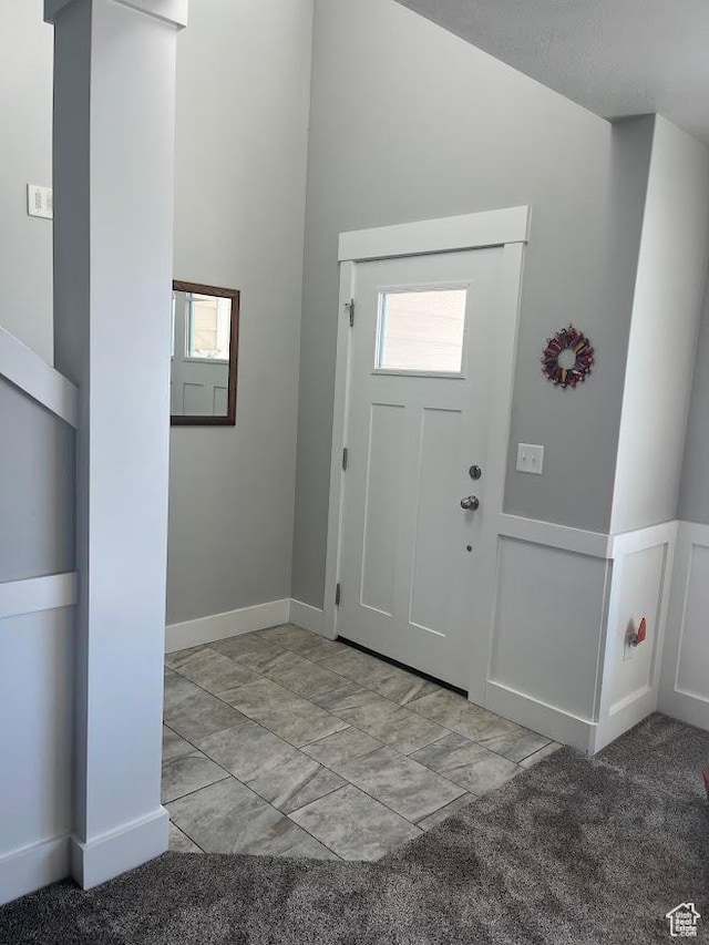 1869 Southpointe Ct, Logan, UT 84341 - foyer entrance featuring a decorative wall, wainscoting, and light carpet