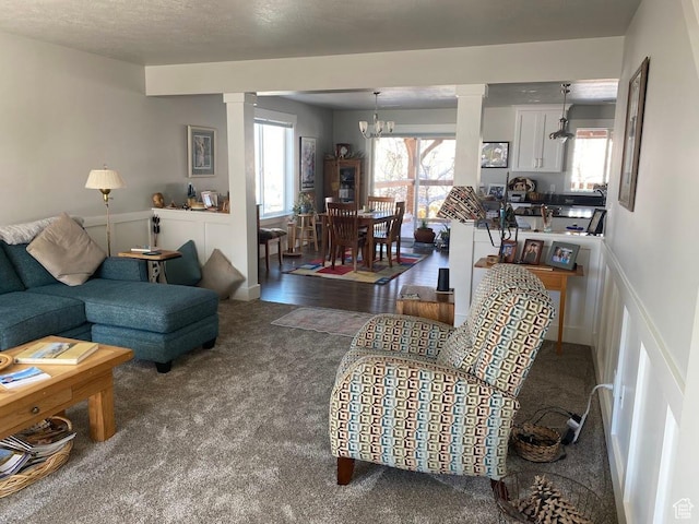 1869 Southpointe Ct, Logan, UT 84341 - carpeted living room with a notable chandelier, a textured ceiling, and ornate columns