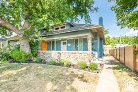 1197 S 700 E, Salt Lake City, UT 84105 - view of front of house with fence, stone siding, and a porch