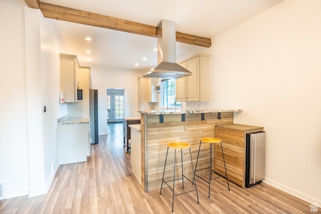 1197 S 700 E, Salt Lake City, UT 84105 - kitchen featuring island range hood, light wood-style flooring, a breakfast bar, beam ceiling, and baseboards