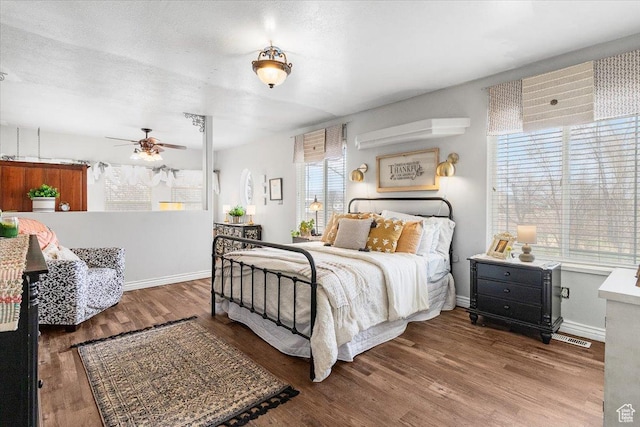 bedroom featuring a textured ceiling, baseboards, and wood finished floors