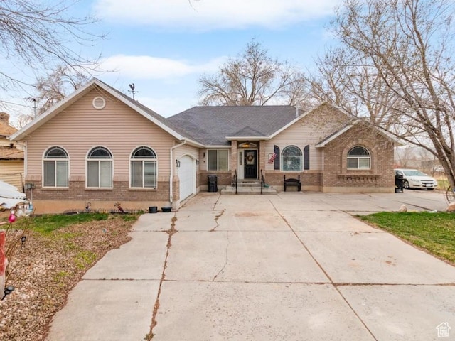 view of front of house with an attached garage, brick siding, and concrete driveway