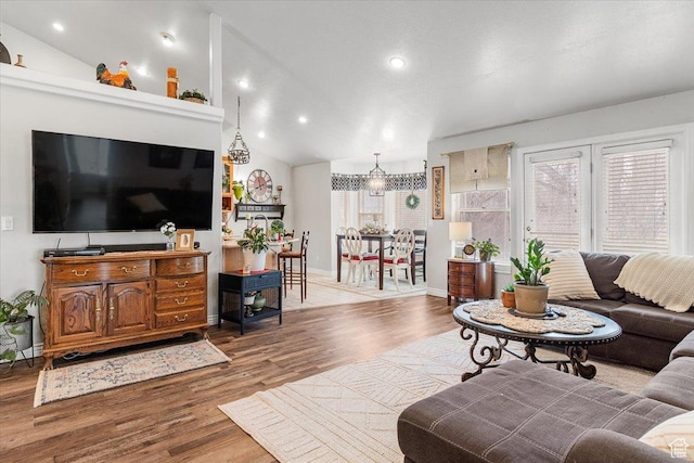 living area featuring baseboards, vaulted ceiling, wood finished floors, and recessed lighting
